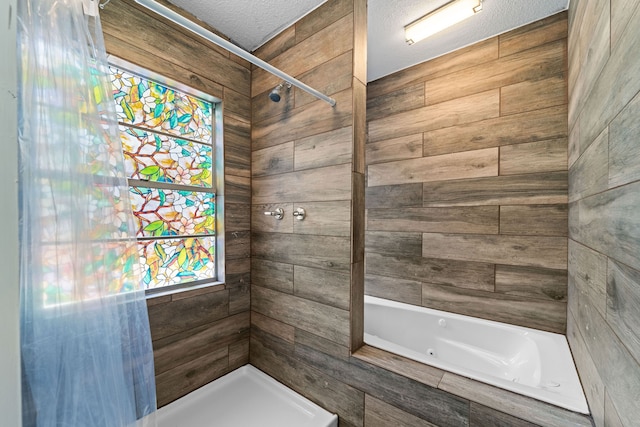 bathroom featuring independent shower and bath and a textured ceiling