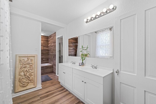 bathroom featuring wood-type flooring, vanity, and a textured ceiling