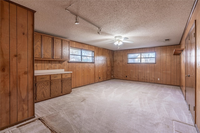 interior space featuring light colored carpet, a healthy amount of sunlight, and a textured ceiling