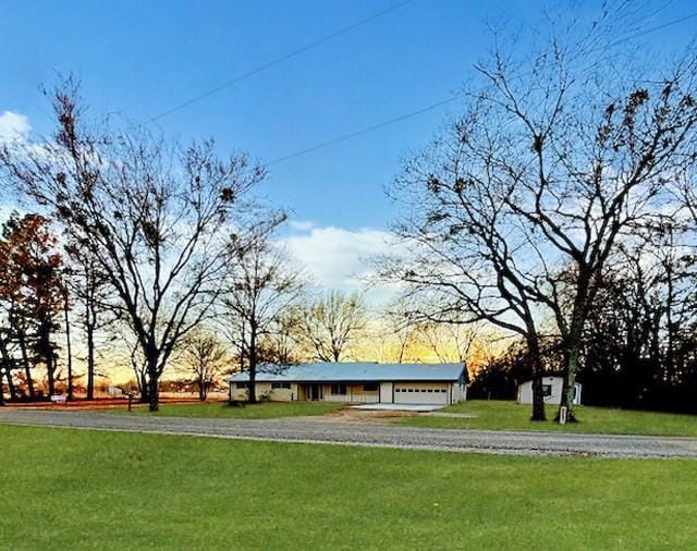 view of property's community with driveway, a lawn, and an attached garage