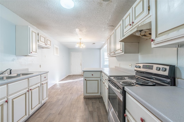 kitchen featuring stainless steel electric stove, sink, decorative light fixtures, a notable chandelier, and light hardwood / wood-style floors