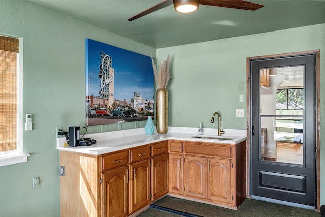 kitchen featuring kitchen peninsula, ceiling fan, and sink