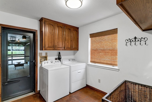 laundry room with cabinets, independent washer and dryer, a textured ceiling, and dark tile patterned floors