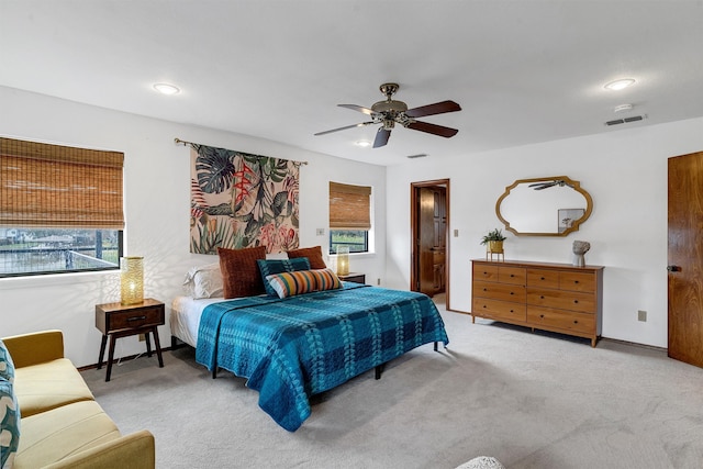 carpeted bedroom with multiple windows and ceiling fan