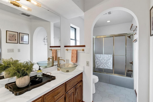 full bathroom with vanity, tile patterned floors, shower / bath combination with glass door, and toilet