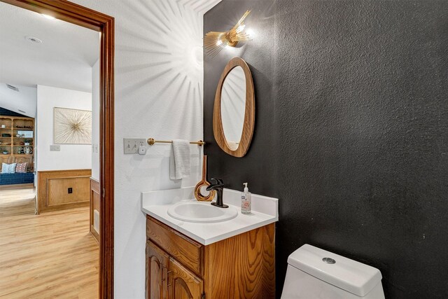 bathroom featuring hardwood / wood-style flooring, vanity, and toilet