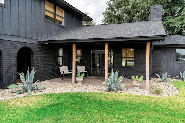 back of property featuring a lawn and a patio