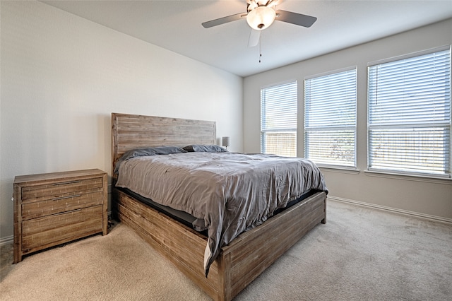 bedroom with ceiling fan and light carpet