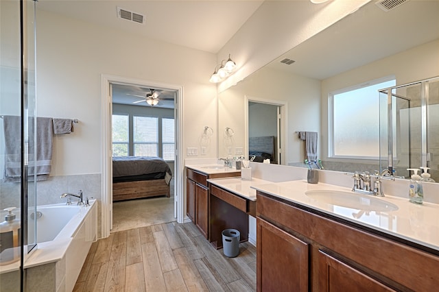 bathroom featuring ceiling fan, vanity, wood-type flooring, and shower with separate bathtub