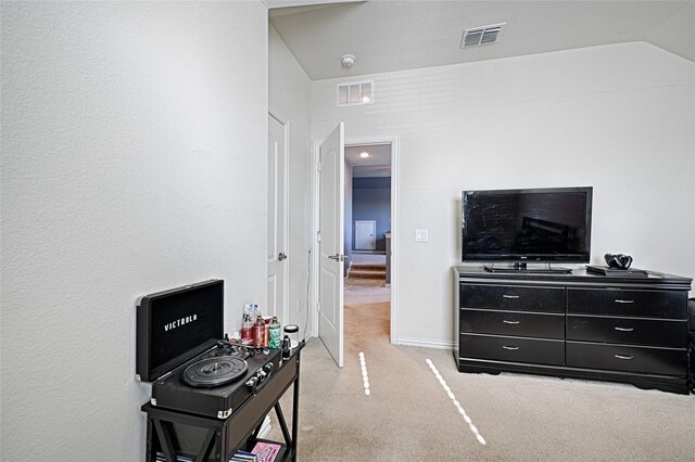 interior space featuring light colored carpet and lofted ceiling