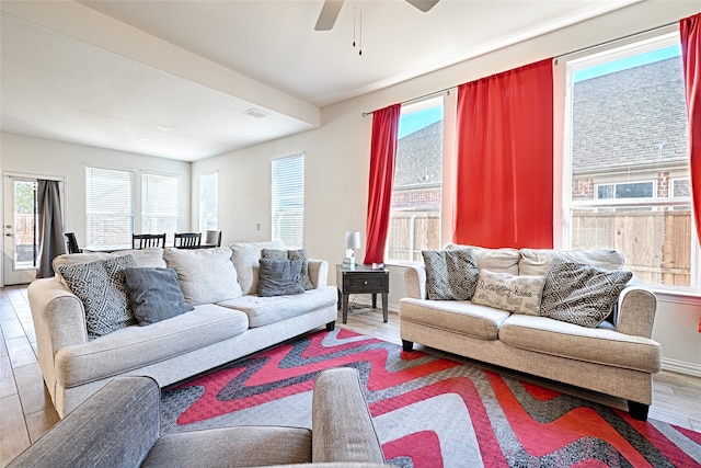 living room with light hardwood / wood-style flooring, ceiling fan, and a healthy amount of sunlight