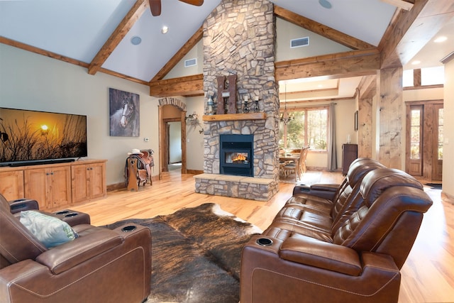 living room featuring a stone fireplace, high vaulted ceiling, ceiling fan, light hardwood / wood-style floors, and beam ceiling