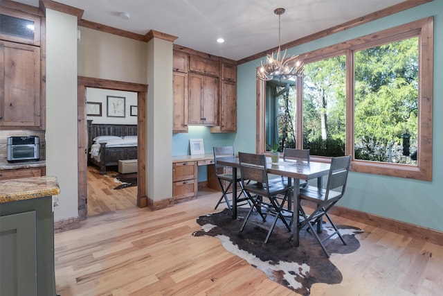 dining space with plenty of natural light, a chandelier, and light wood-type flooring