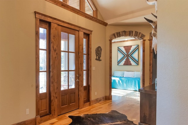 foyer entrance with lofted ceiling and light hardwood / wood-style floors