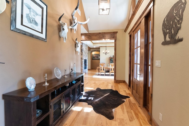 hallway featuring a chandelier and light wood-type flooring