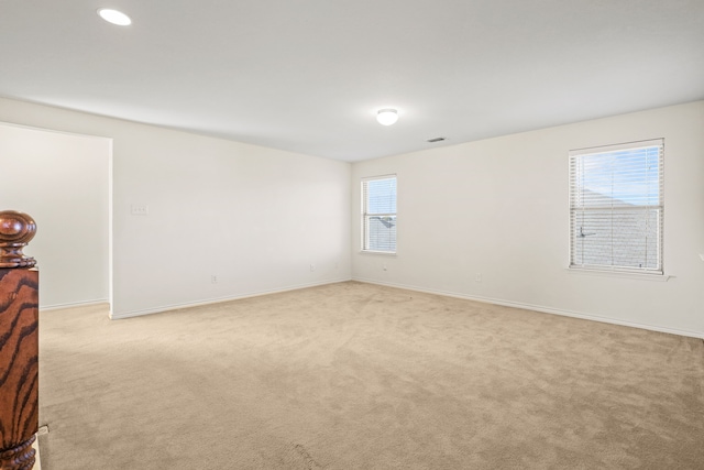 spare room featuring light carpet