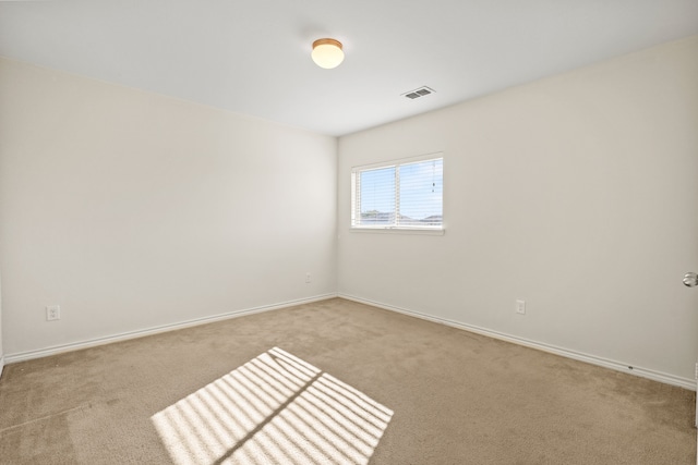 spare room featuring light carpet