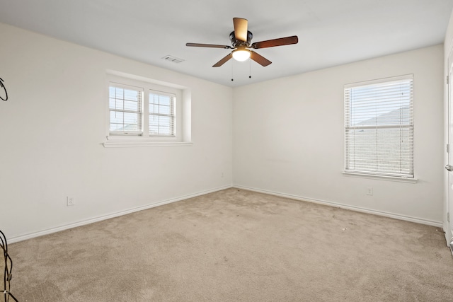 carpeted spare room featuring ceiling fan