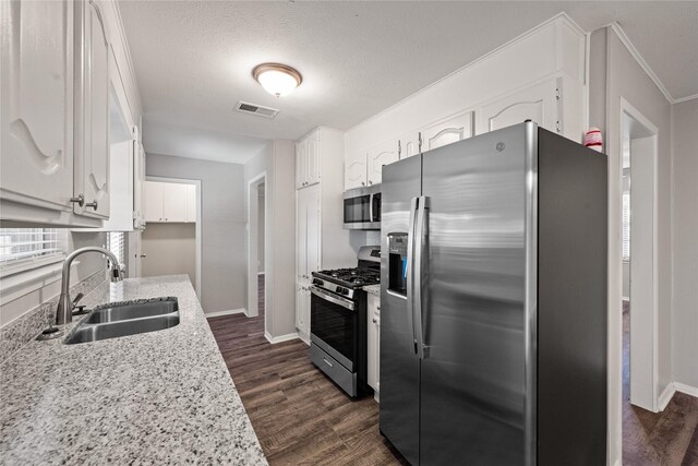 kitchen with sink, dark hardwood / wood-style floors, a textured ceiling, white cabinets, and appliances with stainless steel finishes