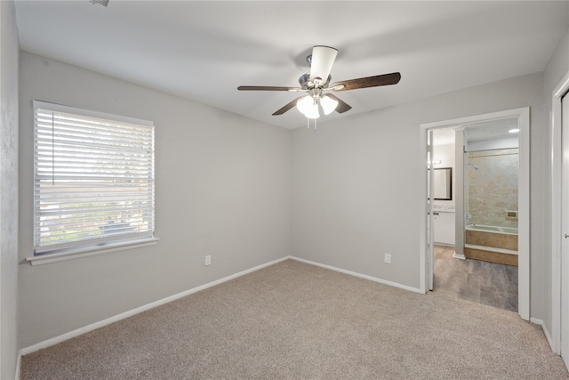 unfurnished bedroom featuring light carpet, ensuite bathroom, and ceiling fan