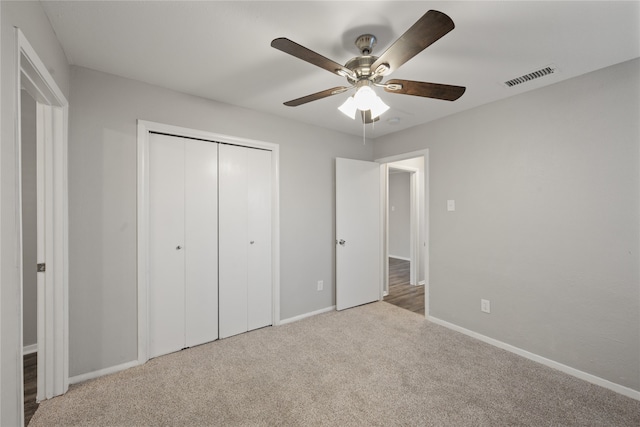 unfurnished bedroom featuring ceiling fan, light carpet, and a closet