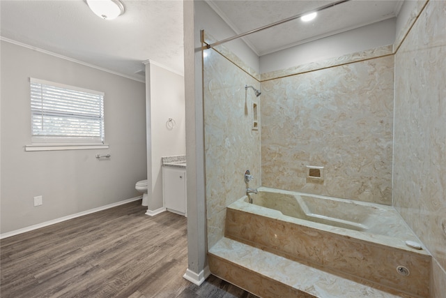 full bathroom featuring vanity, tiled shower / bath combo, toilet, ornamental molding, and wood-type flooring