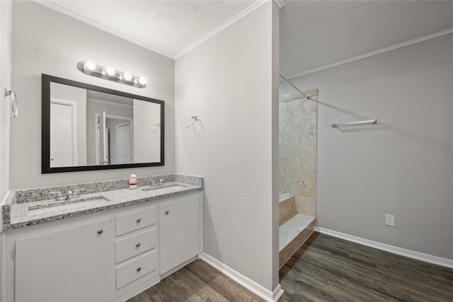 bathroom with vanity, a shower, hardwood / wood-style flooring, ornamental molding, and a textured ceiling