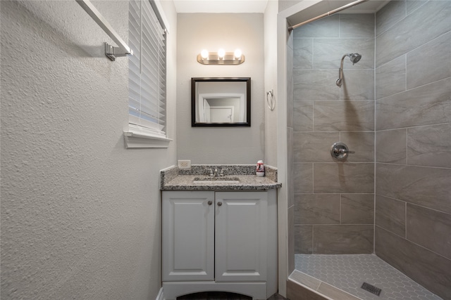 bathroom featuring vanity and tiled shower