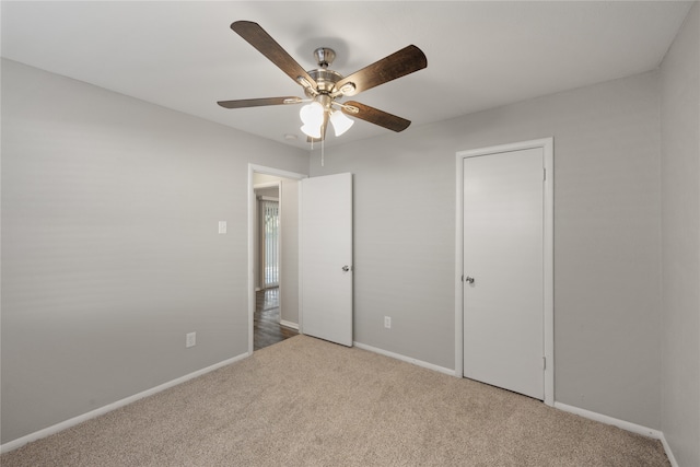 unfurnished bedroom featuring ceiling fan, light carpet, and a closet