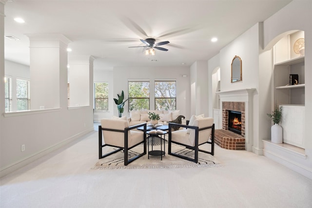 carpeted dining area with a brick fireplace and ceiling fan