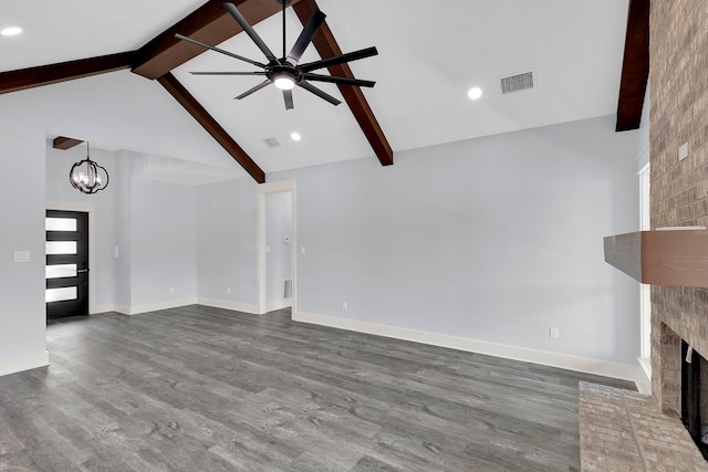 unfurnished living room featuring beam ceiling, ceiling fan with notable chandelier, dark hardwood / wood-style floors, and a brick fireplace