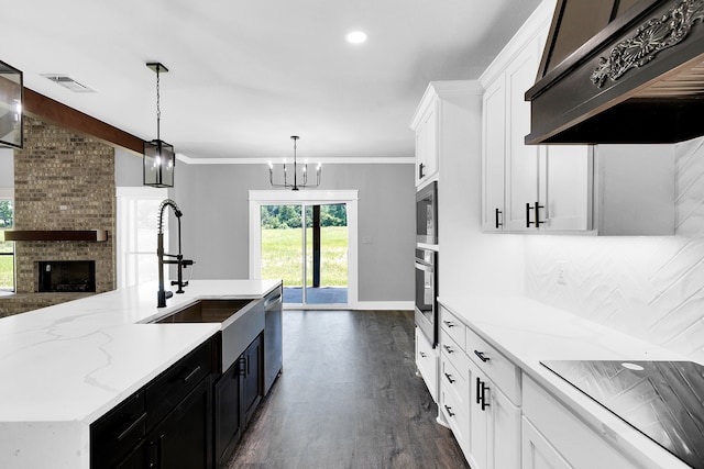 kitchen featuring white cabinetry, appliances with stainless steel finishes, hanging light fixtures, and custom exhaust hood