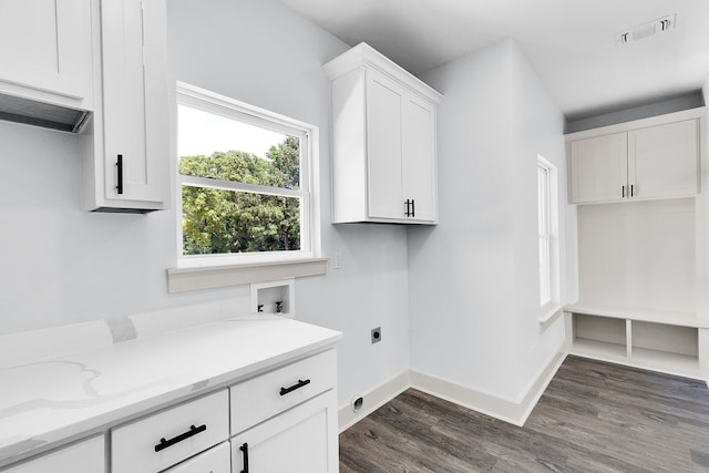 washroom featuring electric dryer hookup, hookup for a washing machine, dark wood-type flooring, and cabinets