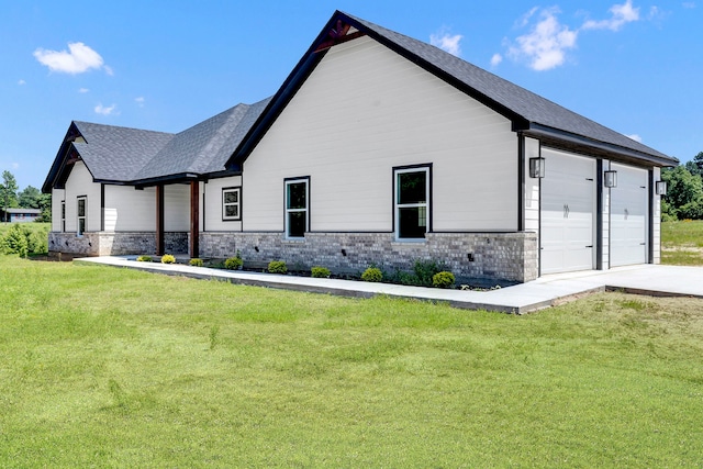 view of side of home with a lawn and a garage