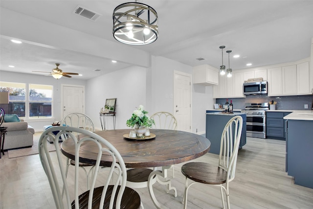 dining space with ceiling fan and light wood-type flooring