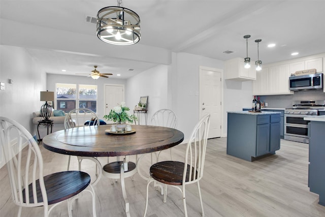 dining area with ceiling fan with notable chandelier and light wood-type flooring