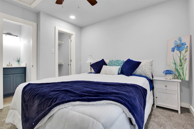 carpeted bedroom featuring a spacious closet, connected bathroom, and ceiling fan