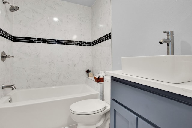 full bathroom featuring vanity, tiled shower / bath, and toilet