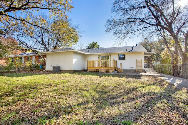 back of property featuring a deck, a lawn, and central air condition unit