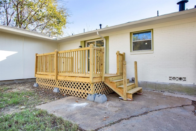 property entrance featuring a wooden deck and a patio area