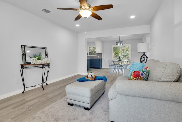 living room featuring ceiling fan and light wood-type flooring