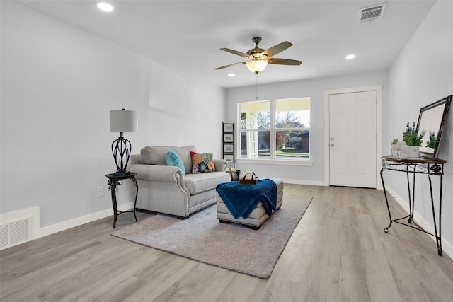 living room featuring light hardwood / wood-style flooring and ceiling fan