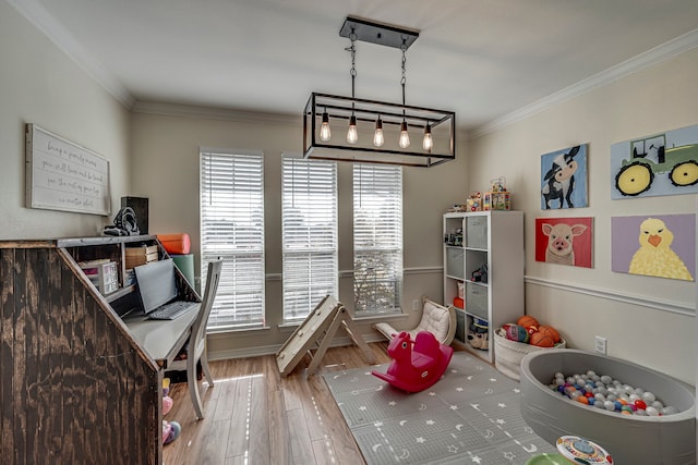 recreation room featuring wood-type flooring, crown molding, and a healthy amount of sunlight