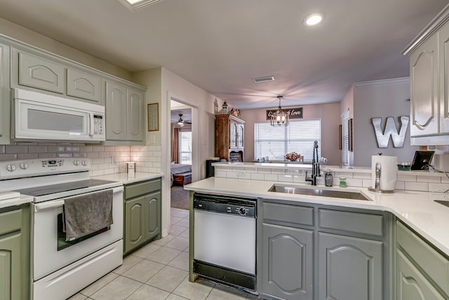 kitchen featuring white appliances, an inviting chandelier, decorative backsplash, sink, and light tile patterned floors