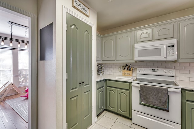 kitchen featuring decorative backsplash, white appliances, a chandelier, and light tile patterned flooring