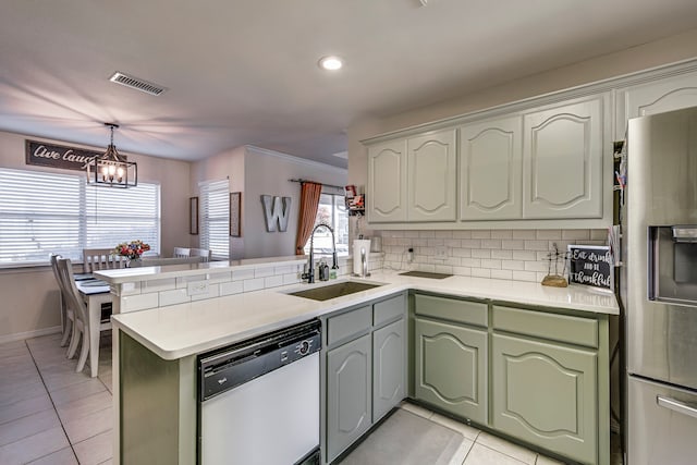 kitchen featuring sink, stainless steel fridge, dishwasher, and kitchen peninsula