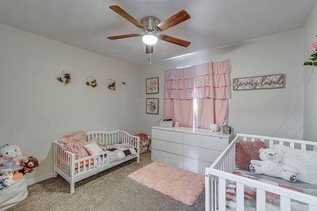 bedroom with ceiling fan, a nursery area, and carpet floors