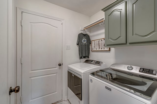 clothes washing area with washer and clothes dryer and cabinets