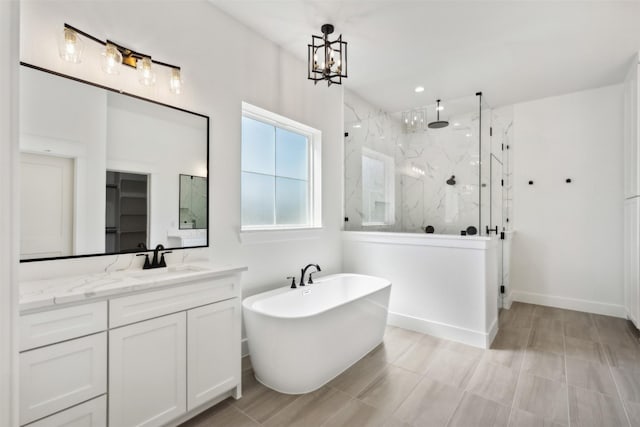 bathroom with vanity, independent shower and bath, and a notable chandelier