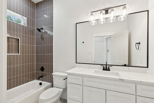 full bathroom featuring vanity, tiled shower / bath combo, and toilet